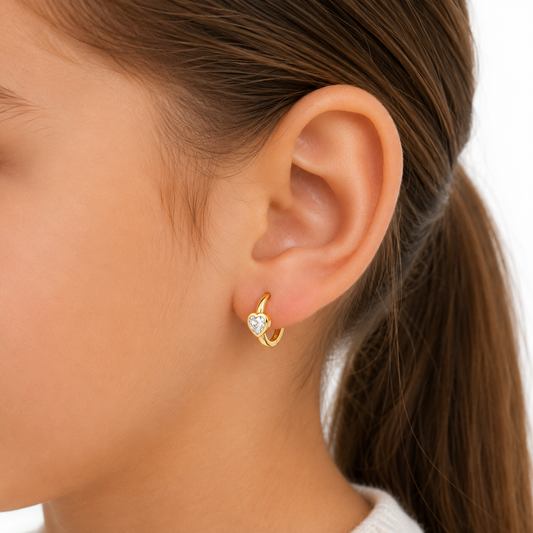 Argollas de corazón con circón en plata ley 925 con baño de oro 18k puestas en una niña de 6 años