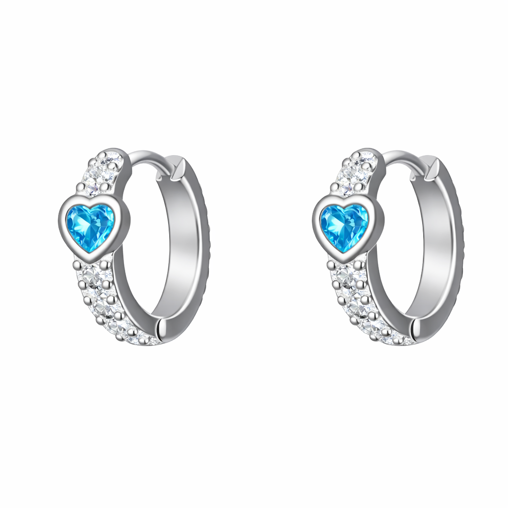 "Par de argollas de plata ley 925 con hileras de circones blancos y un corazón central de circón color azul agua marina sobre fondo blanco."