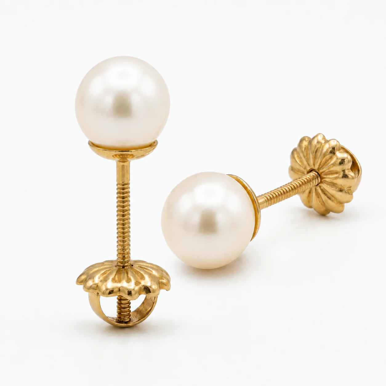Un primer plano de alta resolución de un par de pendientes de perla cultivada de 6 mm y oro amarillo de 18 k, capturando su elegante diseño y brillo natural.