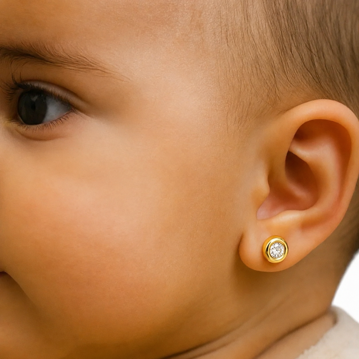 Aros de Oro 18k para Bebé Modelo Dona con Circón, puestos en un bebe 