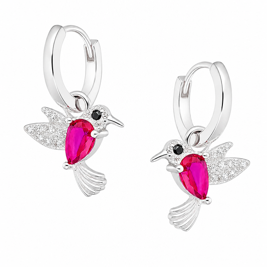 Par de aros argolla de plata ley 925 para niña de 11mm con colgante de colibrí de 11x12mm, que lleva un circón central color rubí y alitas con circones pequeños, sobre fondo blanco.