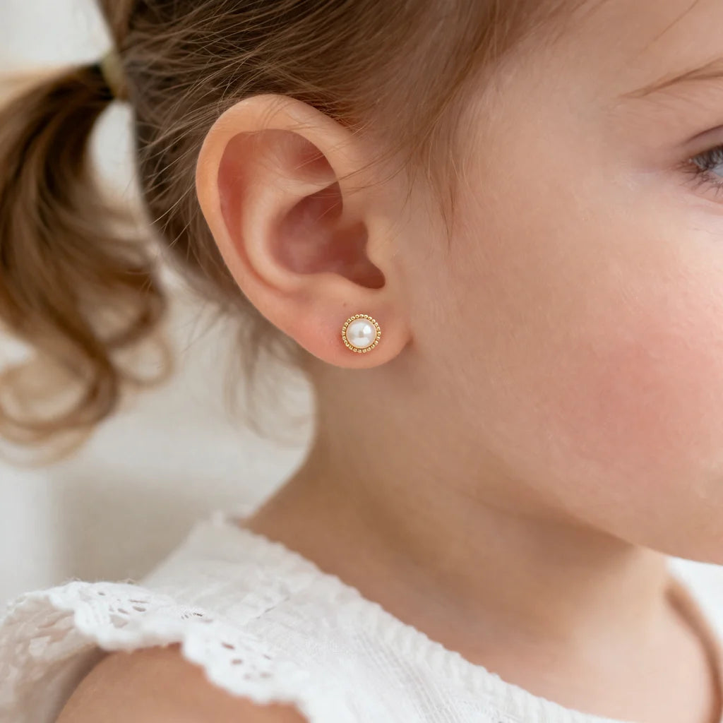 Fotografía de modelo de niña de 3 años usando Aros de Oro 18k con perla cultivada y pistilo payaso.