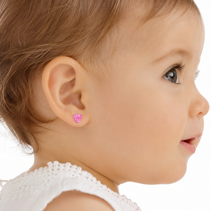 Bebé de 12 meses luciendo aros de corazón con glitter rosado