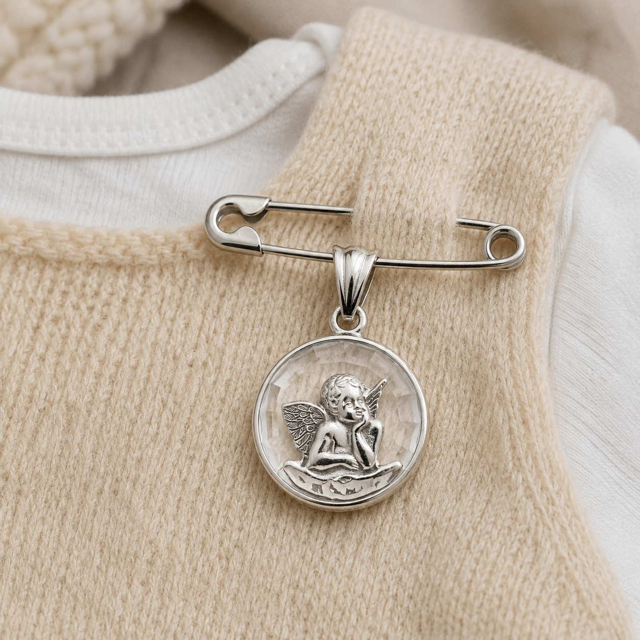 Alfiler de gancho con medalla Ángel de la Guarda en plata puesto en ropa de bebé