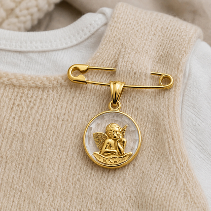 Medalla Ángel de la Guarda en oro 18k macizo con cristal facetado, puesta en la ropa de un bebe